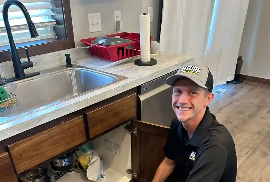 licensed beeline plumber after fixing a leaky faucet in kitchen
